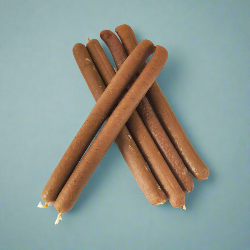 A stack of long salmon and chicken sausages for dogs, laid flat