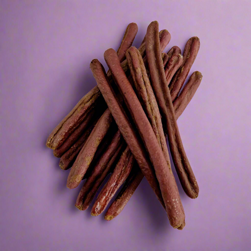 A stack of long pheasant and partridge sausages for dogs, laid flat