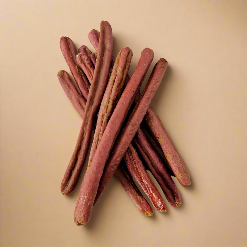 A stack of long rabbit sausages for dogs, laid flat