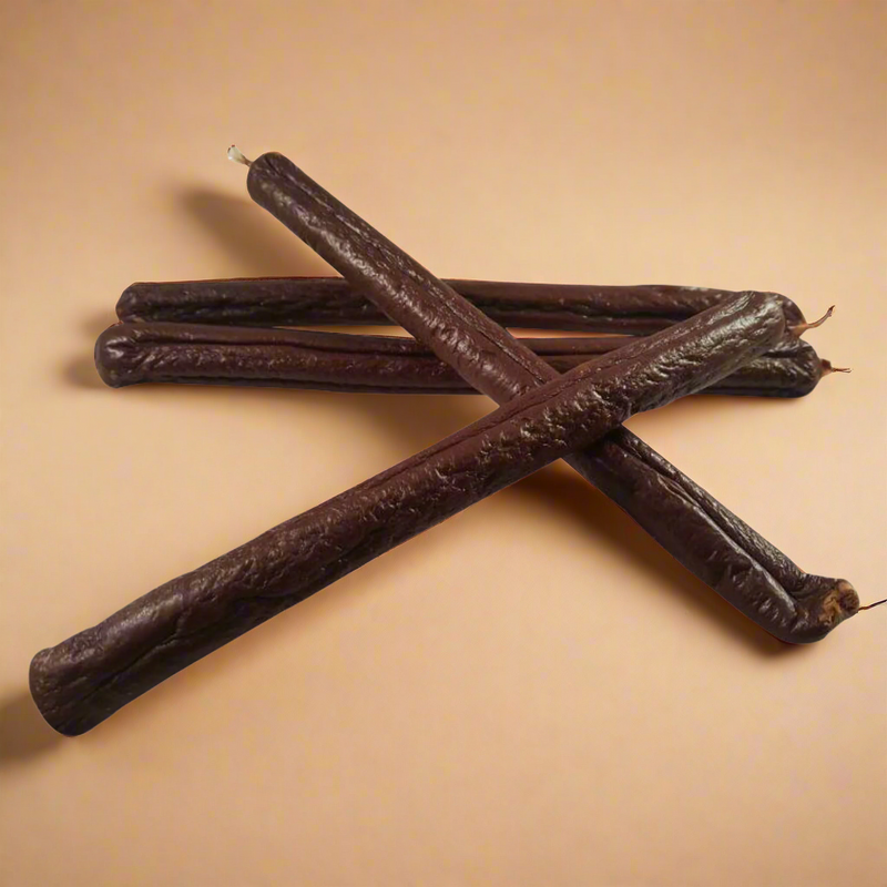 A stack of long black pudding sausages for dogs, laid flat
