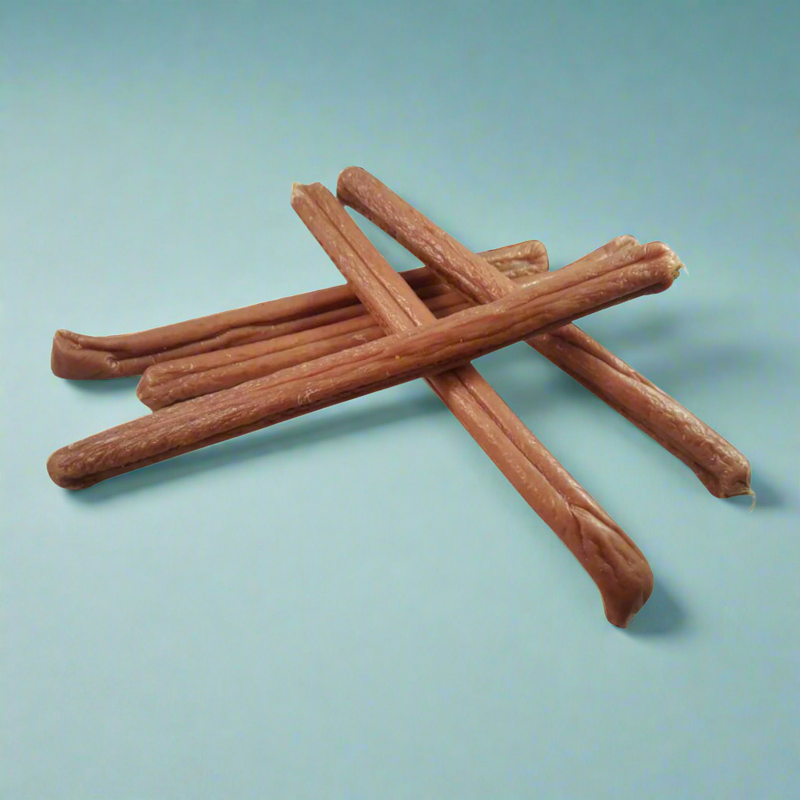 A stack of long chicken and cheese sausages for dogs, laid flat
