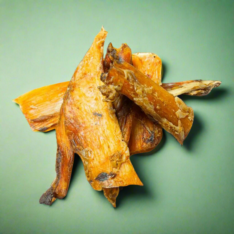 Lengths of dried beef paddywack, the pale neck ligament, laid flat